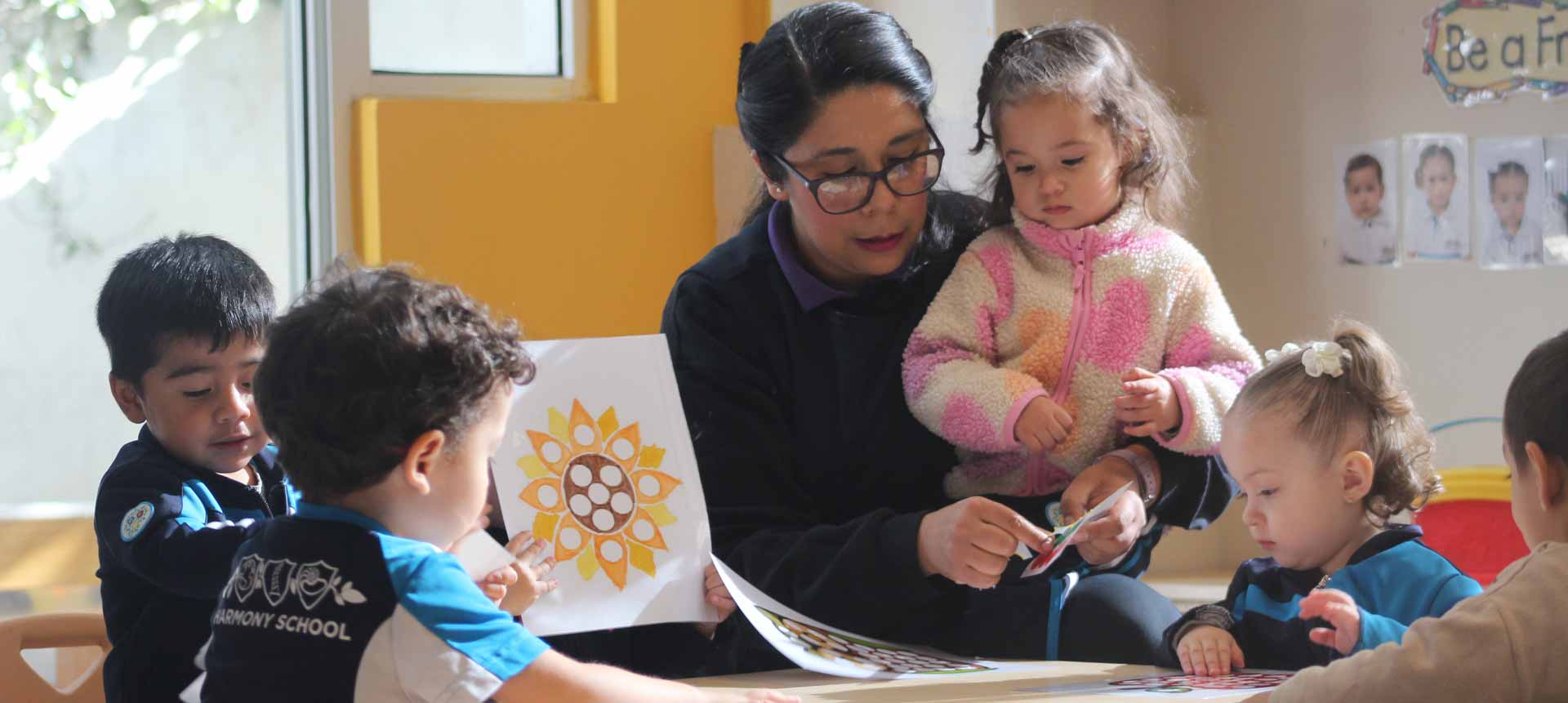 Maestra rodeada de almunos pequeños jugando y aprendiendo