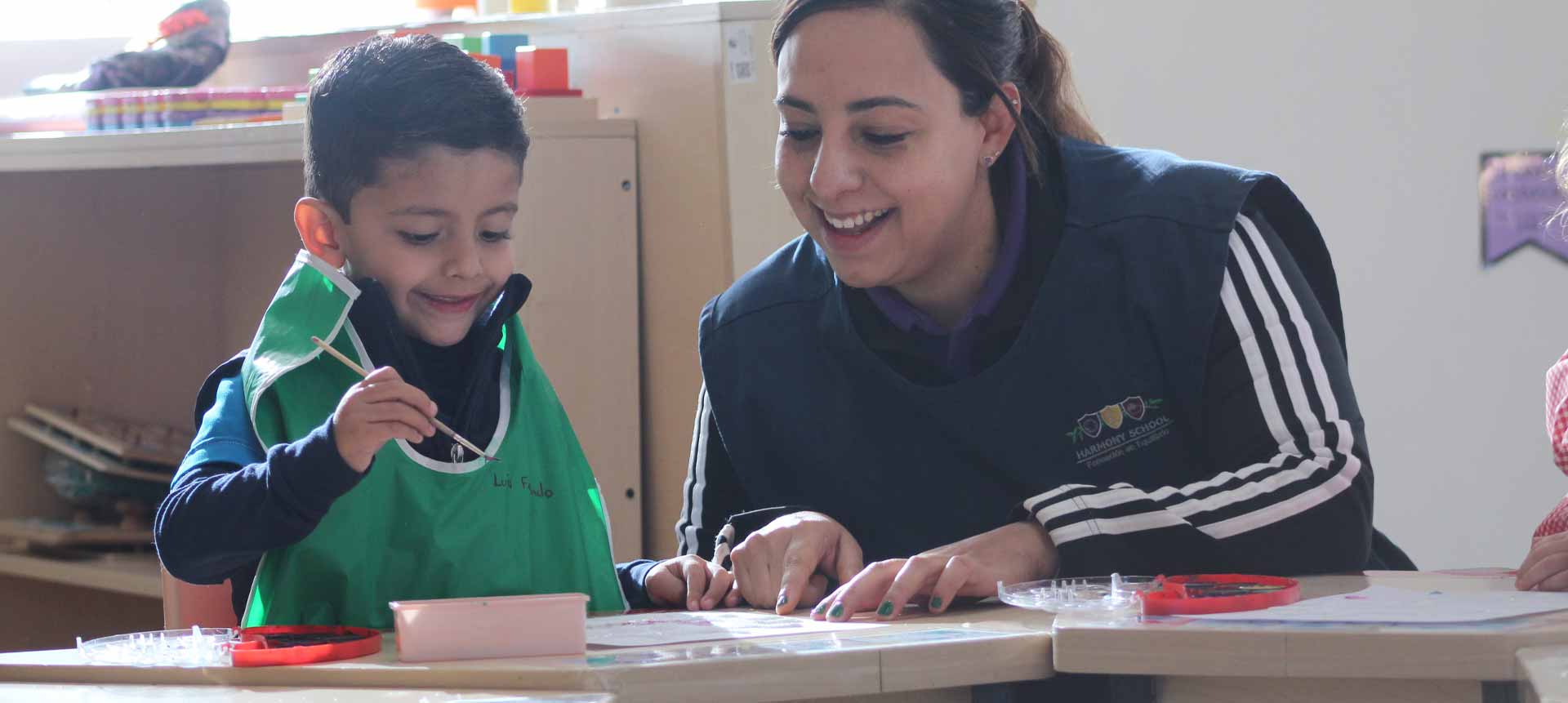 Maestra enseñando a niño pequeño