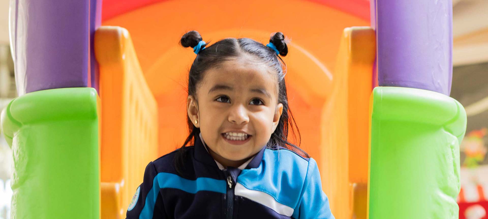 Blog_Felicidad Niña pequeña sonriente en área de juegos