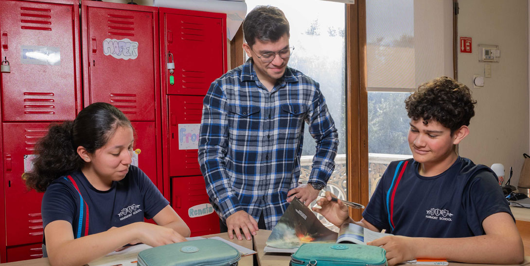 Maestro enseñando a dos alumnos de secundaria.
